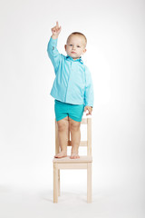 boy on chair and pointing his finger up