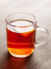Tea with lemon in glass mug on wooden table
