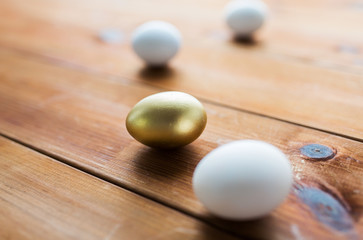 close up of golden and white easter eggs on wood