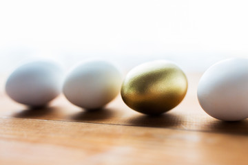 close up of golden and white easter eggs on wood