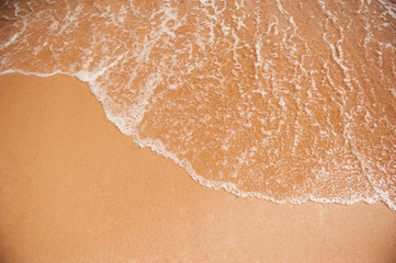 Sea wave on the yellow sand on the beach