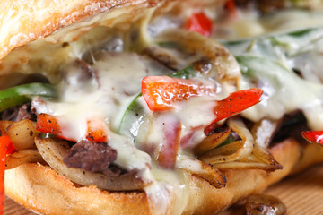 Tasty beef steak sandwich with onions, mushroom and melted provolone cheese in a ciabatta