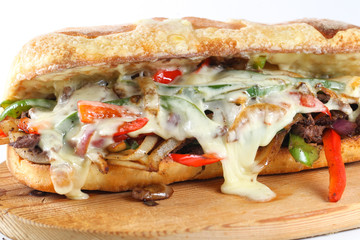 Tasty beef steak sandwich with onions, mushroom and melted provolone cheese in a ciabatta