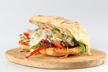 Tasty beef steak sandwich with onions, mushroom and melted provolone cheese in a ciabatta