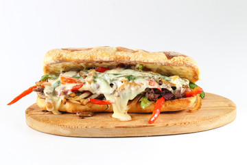Tasty beef steak sandwich with onions, mushroom and melted provolone cheese in a ciabatta