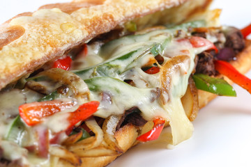 Tasty beef steak sandwich with onions, mushroom and melted provolone cheese in a ciabatta