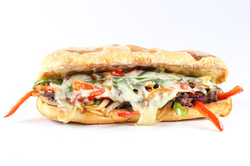 Tasty beef steak sandwich with onions, mushroom and melted provolone cheese in a ciabatta