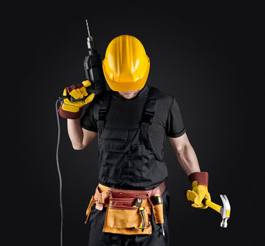 construction worker in helmet with hammer and drill