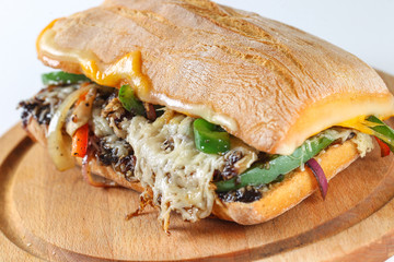 Tasty vegetarian sandwich in a ciabatta on a wodden plate