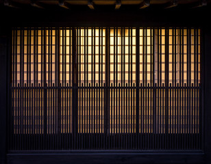Lath wooden wall with background incandescent light. Pattern of vintage wall in Japan.