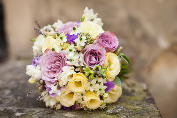 Obraz na płótnie Canvas Elegant fresh rose wedding bouquet on a stone closeup
