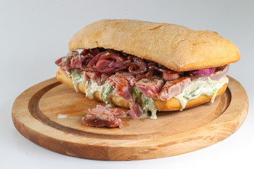 Tasty tuna steak sandwich in a ciabatta with lettuce, onions, Marie Rose sauce and lemon juice