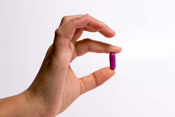 fingers holding a pill