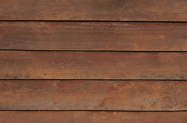 Antique wooden fence with chipped red paint.