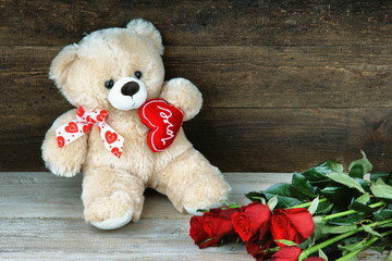 Teddy bear and colorful flower bouquet from red roses