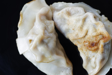 Chinese Pot Stickers on black surface plate