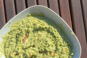 Aerial view closeup of homemade spicy guacamole dip served in bo