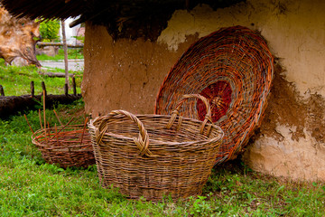 Handmade wicker basket next to a mud wall