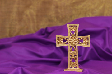 Ornate cross with purple and gold background