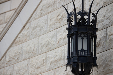 Fototapeta na wymiar black street lamp and a stone wall