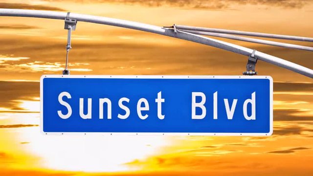Sunset Blvd street sign with time lapse sunset sky in Los Angeles, California.