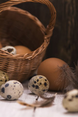 Obraz na płótnie Canvas Fresh raw quail and hen's eggs, jar of milk and rustic basket over wooden background. Selective focus