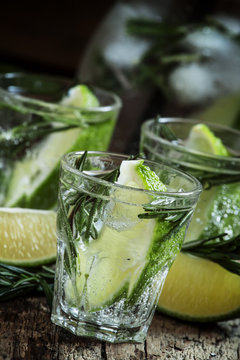 Refreshing drink with rosemary, lime and honey on the old wooden