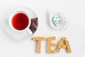 Fruit tea on white background, top view. Word tea made from brown cube sugar.