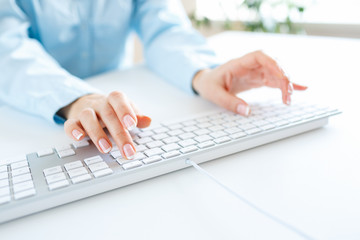 Woman office worker typing on the keyboard