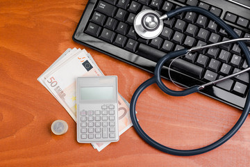 Stethoscope on a keyboard with a calculator