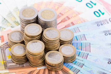 A pile of coins on a fan of bank notes