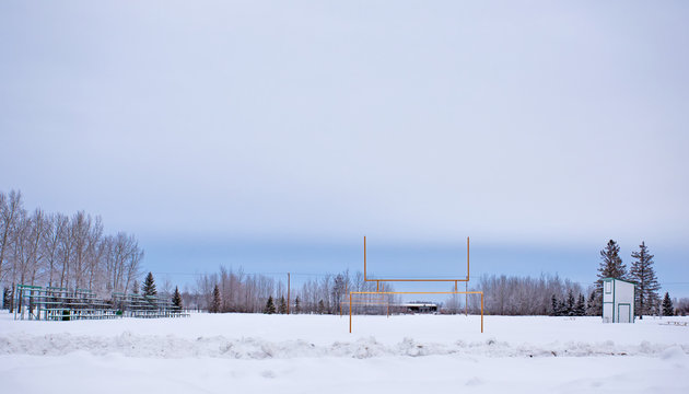 Spectator Bleachers And A Sound Booth By A Snow Covered Football Field In A Winter Landscape