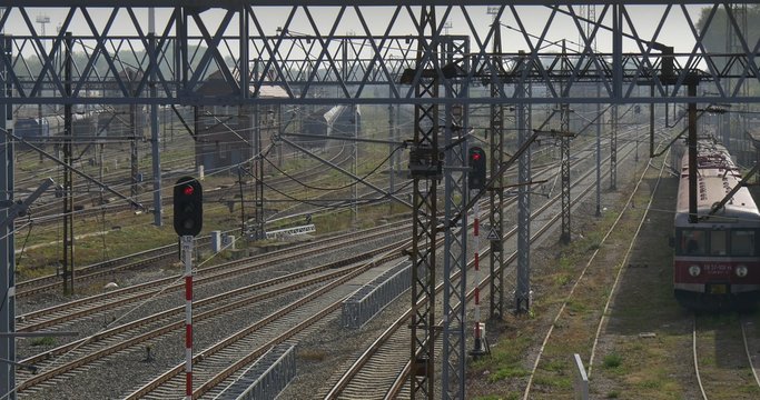 Supports And Lines Of The Railroad Contact Network On The Right Side Electric Train Stands On The Track Input Lights Semaphores Cloudy Autumn Day