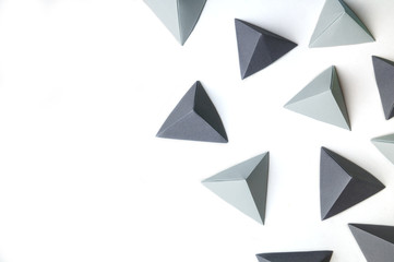 Creative background with black and gray origami tetrahedrons with free copy space on the left side. Great for using in web. - obrazy, fototapety, plakaty