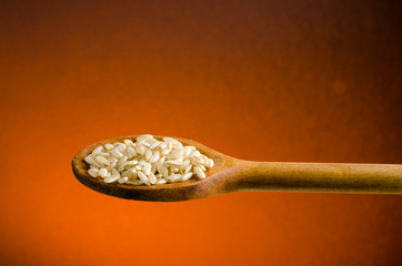 rice in a spoon, close up, color background.