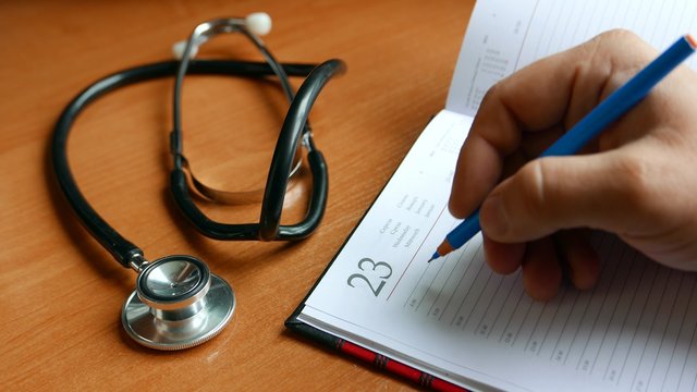 medical diagnosis, the doctor writes in a notebook medical records