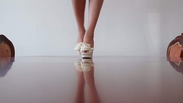 Beautiful sexy bride with amazing long legs  in white high heels stands on the table close up