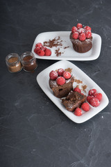 Pasteles de chocolate con frambuesas y tarritos de cacao