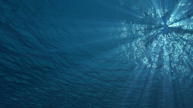 4K blue underwater ocean waves seamless loop animation, light rays pass through the water
