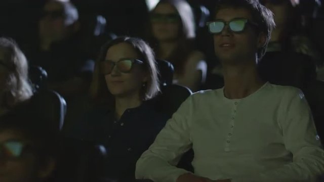People are having fun while watching 5d film screening in cinema.  Shot on RED Cinema Camera.