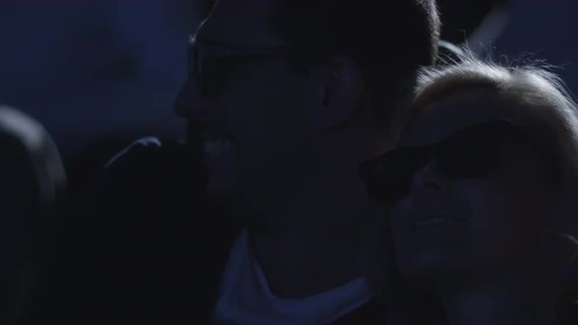 Close-up footage of a couple embrace each other while having fun watching 5d film screening in cinema.  Shot on RED Cinema Camera.