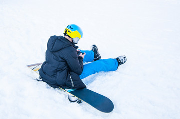 Fototapeta na wymiar Snowboarder sitting on snow background