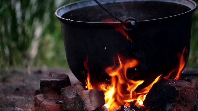 picnic fire under a cauldron in nature, fish soup after fishing