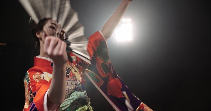 4K beautiful Japanese geisha dancing on stage and posing for the camera,the smoke in the background, slow motion