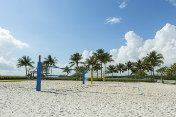 beach volleyball net on a sunny beach, with palm trees