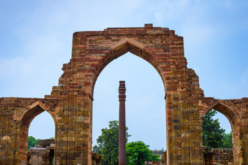 Fototapeta na wymiar Iron pillar in Qutub complex - metallurgical curiosity. Qutub Complex, Delhi, India