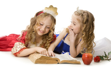 Two Happy Little Princesses Reading a Magic Book