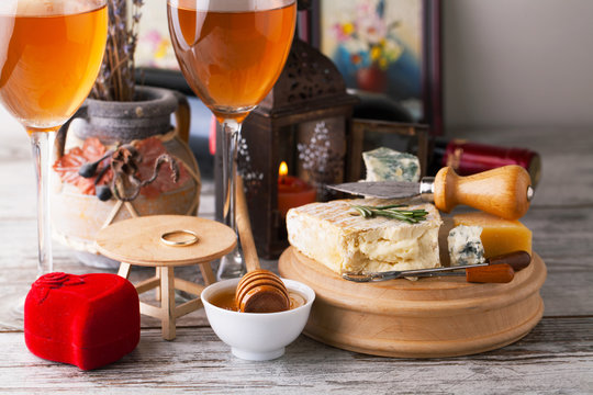 Delicious cheeses on a board with honey, nuts and wine