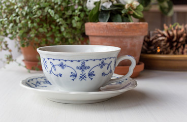 tea cup / white teacup with delicate blue pattern on a table 