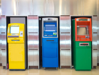 Three different atm machine againt aluminum wall